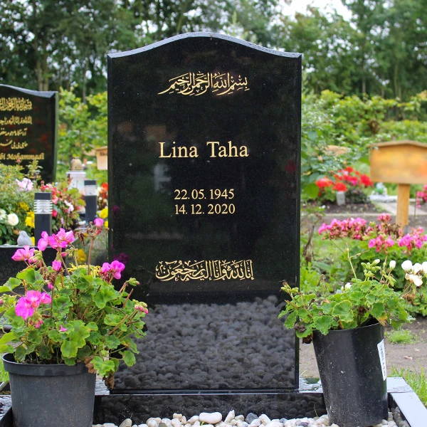 Schwarzer Grabstein mit goldenem Koranvers und islamischer Kalligrafie